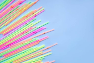 Mavi arka planda renkli plastik pipetler. Kokteyl tüpleri.