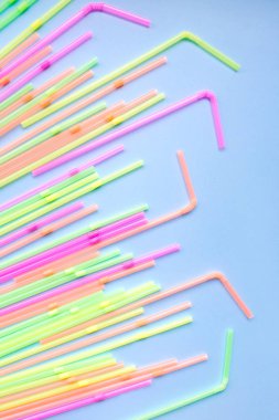 Mavi arka planda renkli plastik pipetler. Kokteyl tüpleri.