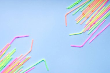 Mavi arka planda renkli plastik pipetler. Kokteyl tüpleri.