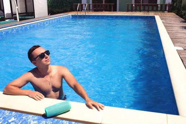 매력적인 젊은 남자 에 선글라스 차가운 에 the 수영장. — 스톡 사진