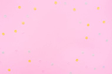 Çok renkli konfeti ile pembe pastel şenlikli arka plan.