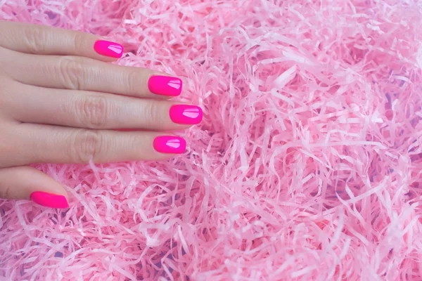 Elegante manicure feminina na moda. Neon plástico rosa unhas no fundo confete . — Fotografia de Stock