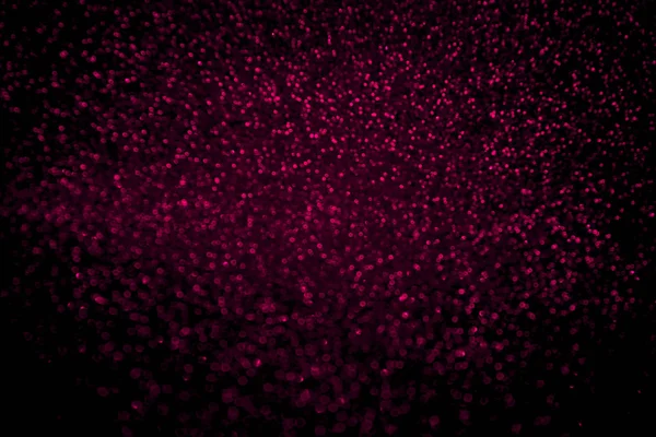 Resumido plástico rosa brillo confeti brilla sobre fondo negro . — Foto de Stock