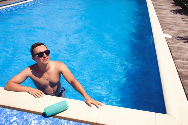 매력적인 젊은 남자 에 선글라스 차가운 에 the 수영장. — 스톡 사진
