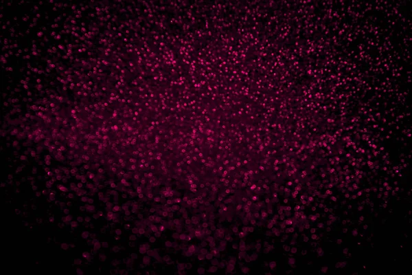 Abstrait plastique rose paillettes confettis scintille sur fond noir . — Photo