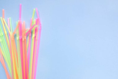 Mavi arka planda renkli plastik pipetler. Kokteyl tüpleri.