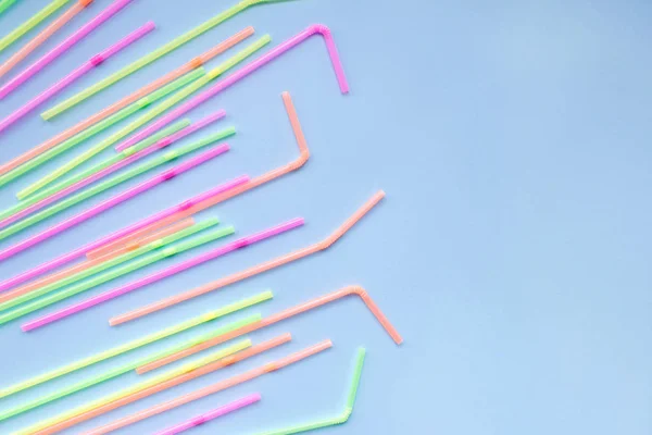 Kleurrijke kunststof rietjes op blauwe achtergrond. Cocktail tubes. — Stockfoto