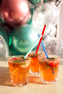 Nane ile narenciye ezilmiş buz soğuk ferahlatıcı kokteyl. Balonların arka planda çilek soda içecek cam.