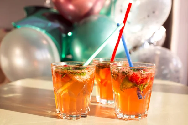 Nane ile narenciye ezilmiş buz soğuk ferahlatıcı kokteyl. Balonların arka planda çilek soda içecek cam.