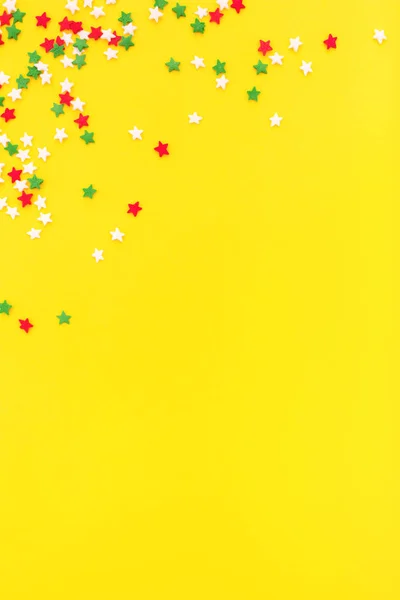 Çok renkli şenlikli yıldızlar sarı arka plan üzerinde bir çerçeve olarak serpilir. — Stok fotoğraf