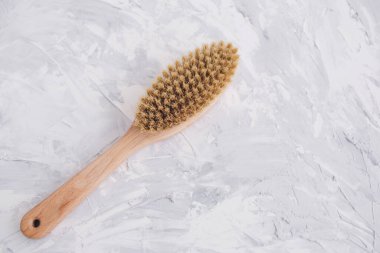 Gri bir arka planda vücut için fırça. Güzellik ürünleri. Doğal malzeme. Masaj salonu konsepti. Düz konum, kopyalama alanı, üst görünüm. Cilt konsepti organik tahta vücut masajı fırçası.  