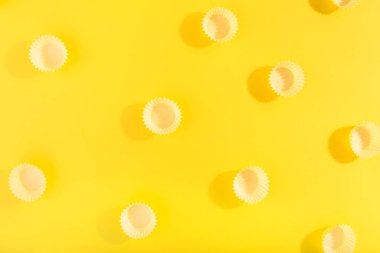 Parlak sarı arka planda sarı şapkalı moda desen. Asgari konsept.