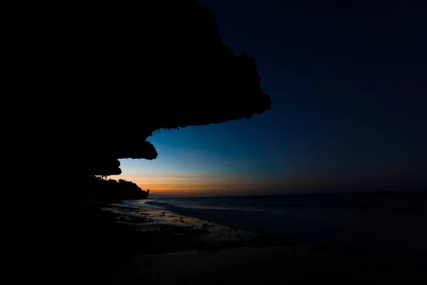 Ocean and sea rocks with the moon rising after sunset, Zanzibar, Africa