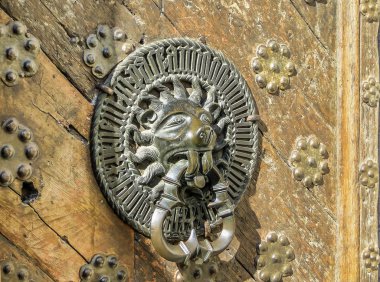 Eski ahşap kapı üzerinde aslan şeklinde oyma kapı kolu