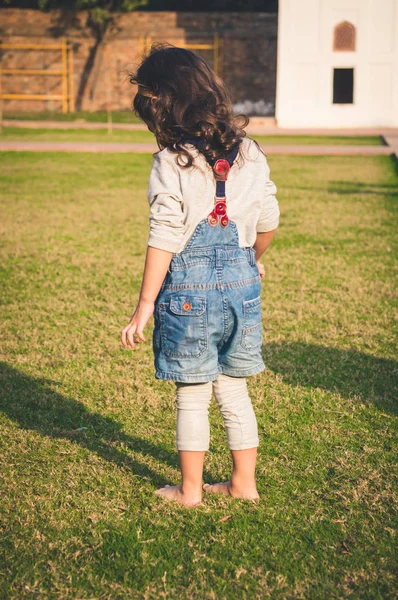 어린 소녀 스테핑 에 녹색 잔디 맨발 — 스톡 사진