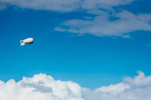 White airship with camera floating in sky