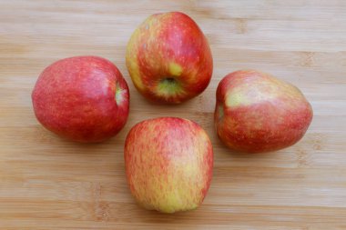 Grup dört kırmızı elma ahşap yüzey üzerine yerleştirilir