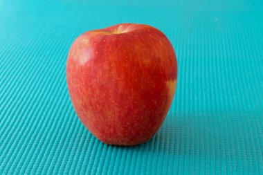 Kırmızı elma gökyüzü mavi doku üzerinde yerleştirilir. blurY arka plan ile