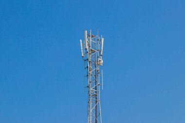 Gümüş rengi mobil, ağaçlar ve mavi gökyüzü ile baz istasyonu