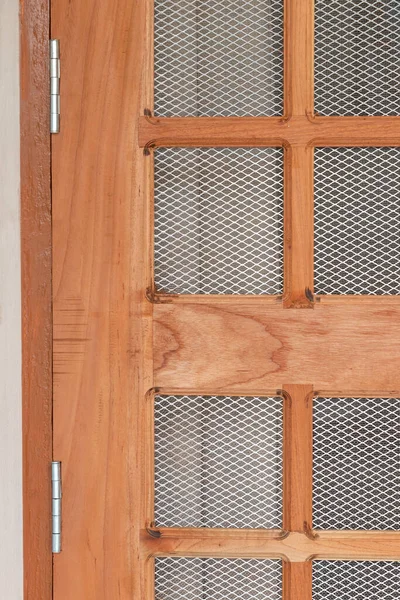 Steel door hinges fitted on wooden net grill door, close up view
