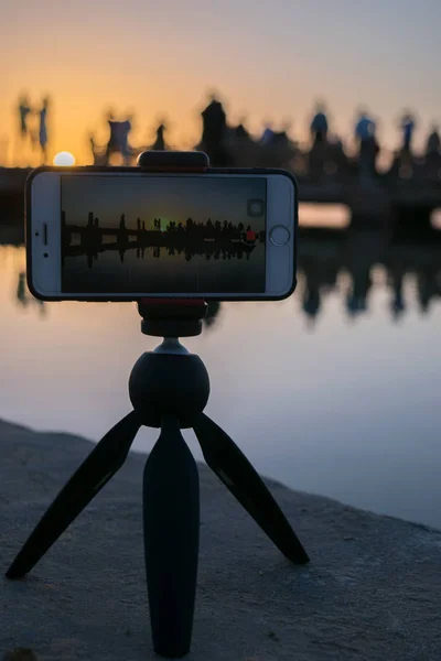 Silhouette and Reflection on calm wateron mobile screen in Fatnas Island , Siwa Egypt