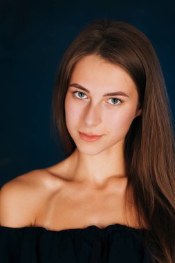 Karanlık bir stüdyoda güzel bir kızın portresi..