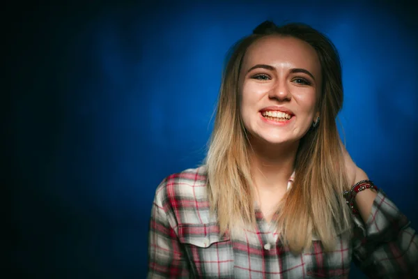 肖像画スタジオに青色の背景で微笑んでいる女の子 — ストック写真