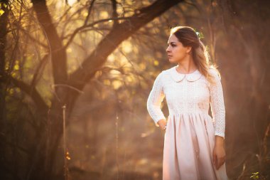 Gün batımı bir arka plan üzerinde bir alanda güzel kız.