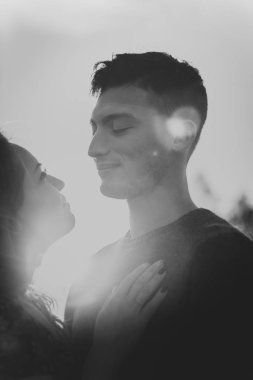 Bir adam ve kız bir gün batımı arka plan alanda blackwhite siluetleri.