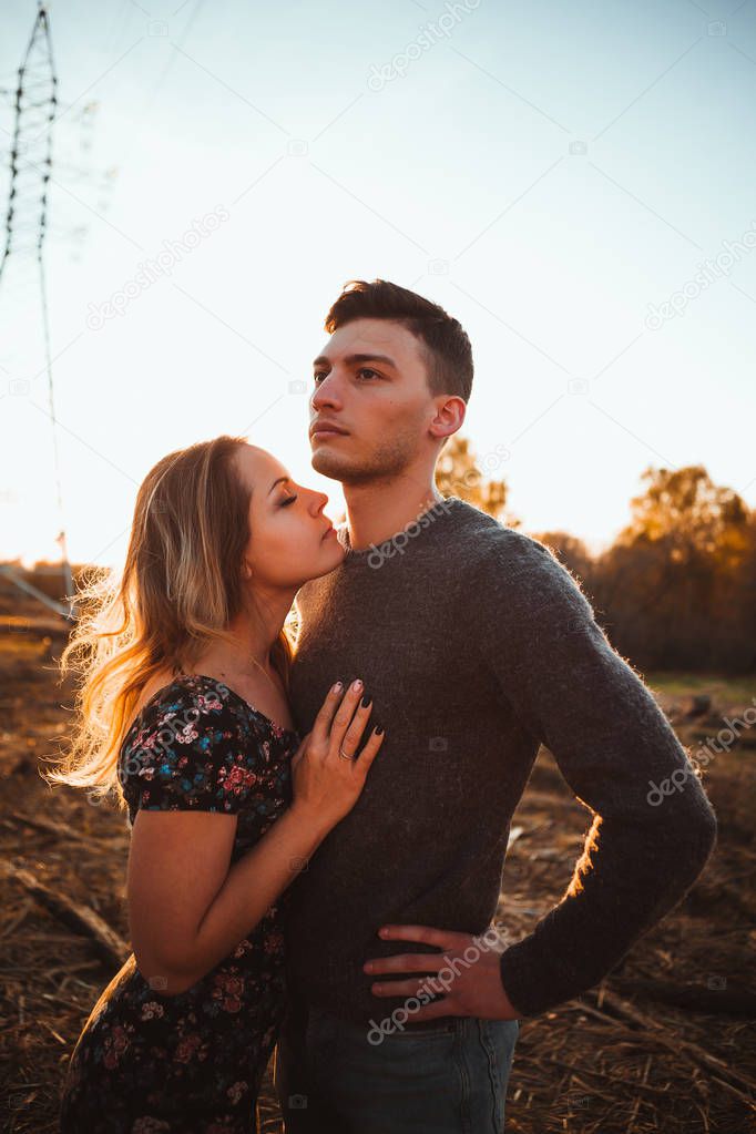 guy and girl in the field on the sunset background.