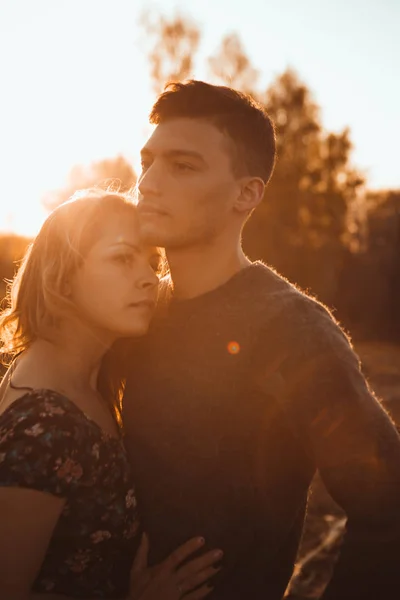 在夕阳背景下的田野里的男人和女孩 — 图库照片