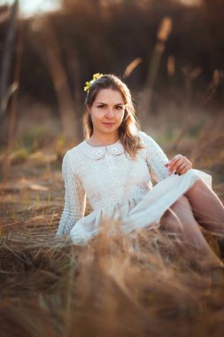 Kız günbatımı arka plan alanında oturuyor.