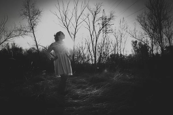 Gün batımı bir arka plan üzerinde bir alanda Blackwhite fotoğraf kız.