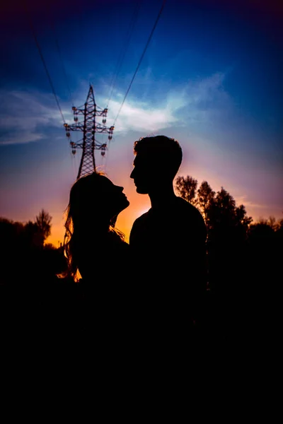 夕阳背景下田野中的一男一女剪影 — 图库照片