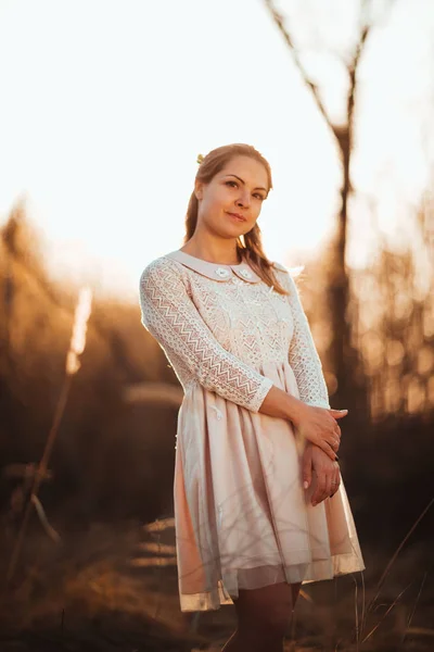美丽的女孩站在田野上日落背景 — 图库照片