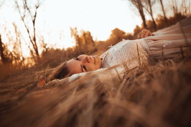 alan günbatımı bir arka plan üzerinde yatan kız.