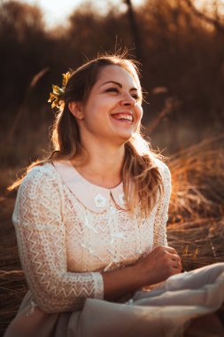 Kız günbatımı arka plan alanında oturuyor.