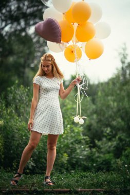 Balonları olan genç bir kız..
