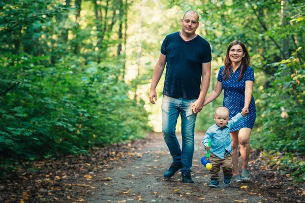 背景の森の息子と幸せな家族 — ストック写真