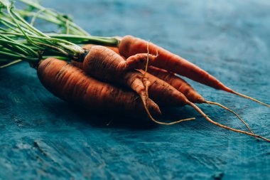 Mavi ahşap arka planda taze havuç..