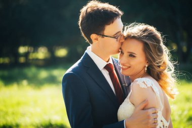 Gelin ve damat doğa özgeçmişlerine kucaklayan.