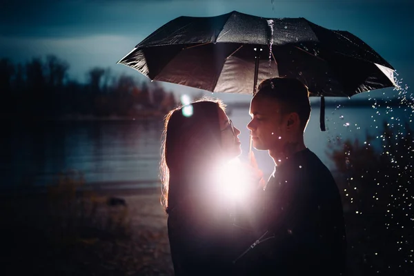 年轻的男人和女人下的伞和雨 — 图库照片