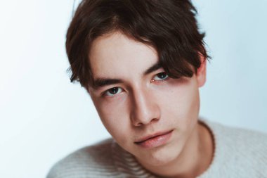 Stüdyo portre genç adam beyaz arka planda gri süveterli.