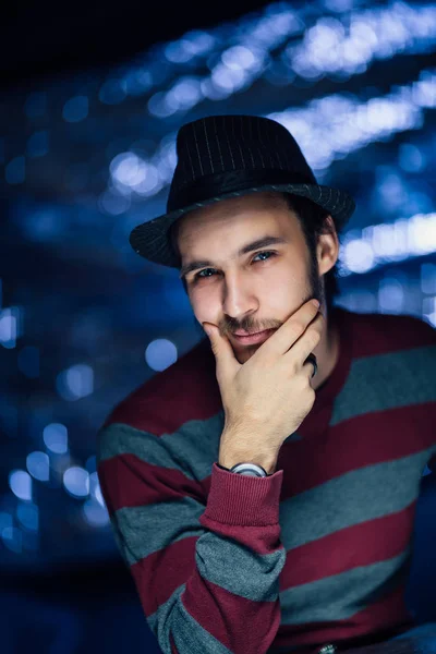 portrait of a guy in a hat on a blurred background.