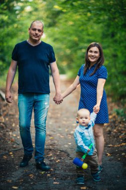 Arka plandaki ormanda oğluyla mutlu bir aile.