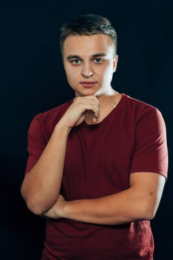 Karanlık bir arka planda genç bir adamın portresi.