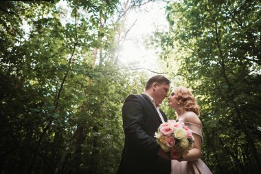 Gelin ve damat dans orman arka plan ve güneş ışığı.