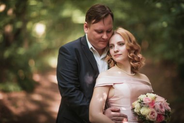 Gelin ve damat dans orman arka plan ve güneş ışığı.