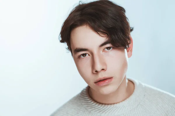 白い背景のグレーのセーター スタジオ肖像画の若い男 — ストック写真