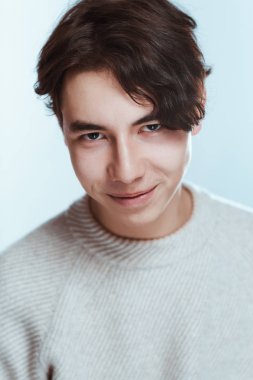 bir stüdyoda bir genç esmer adam portresi.